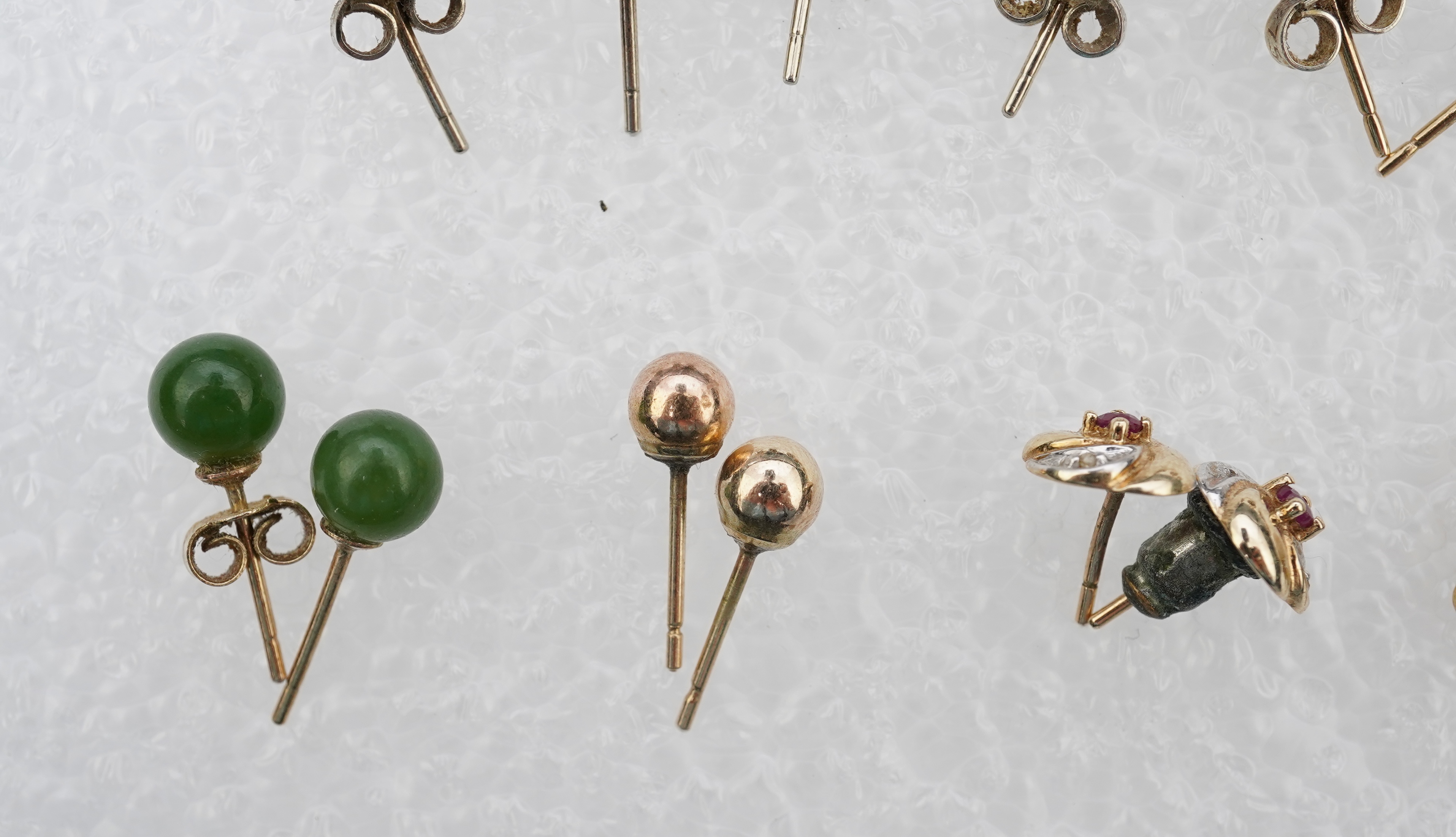 Four assorted pairs of 9ct and gem set ear studs including peridot and cultured pearl, together with three other assorted pairs yellow or white metal ear studs and two odd ear studs.